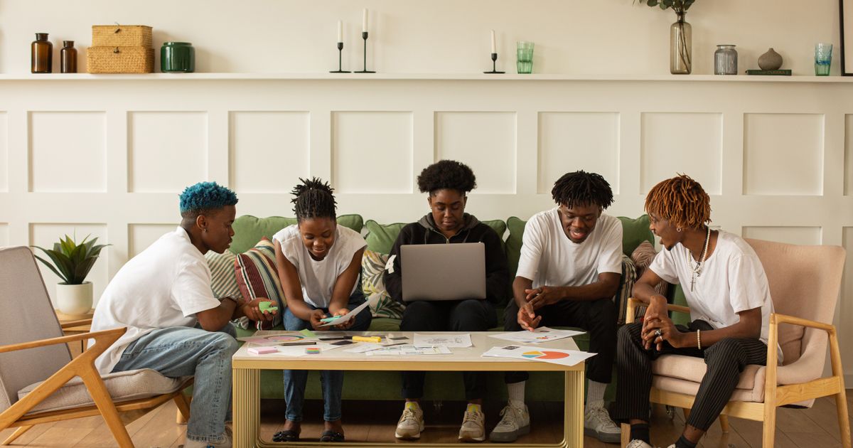 Team of people collaborating on a project together at a shared workspace