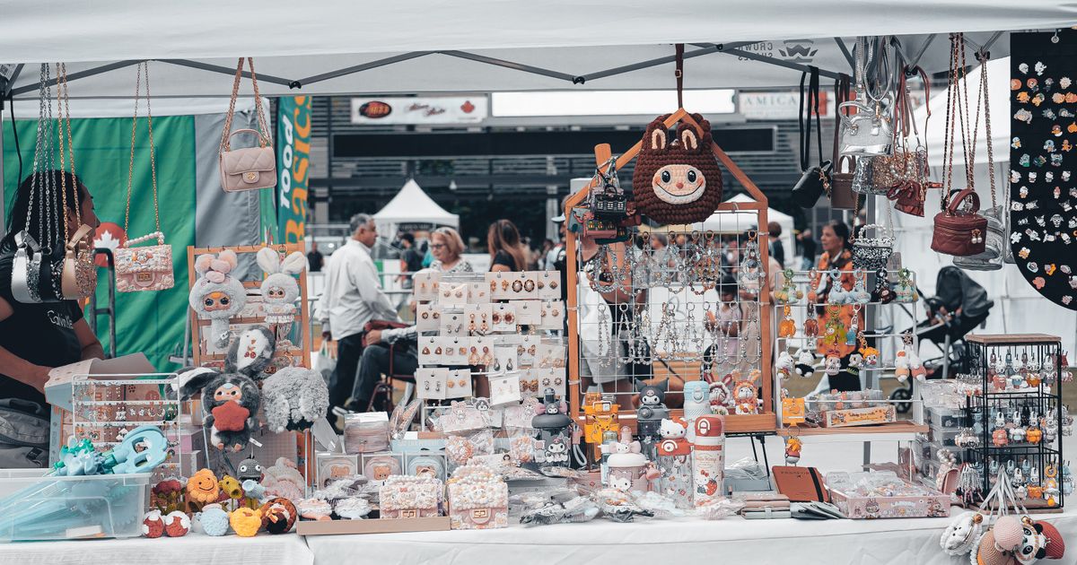 People browsing and engaging at an outdoor street market with product booths and displays