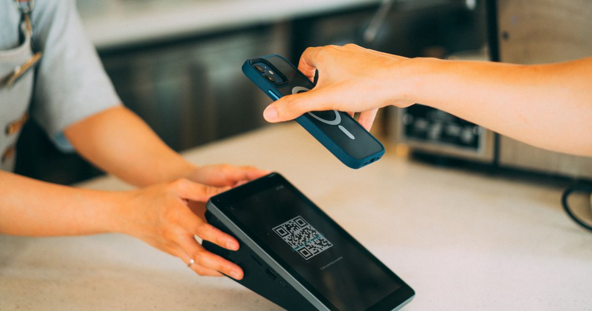 Close-up of a person scanning a QR code with a smartphone for contactless engagement