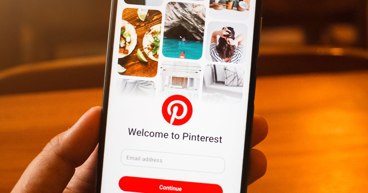 Hand holding a smartphone showing the Pinterest app