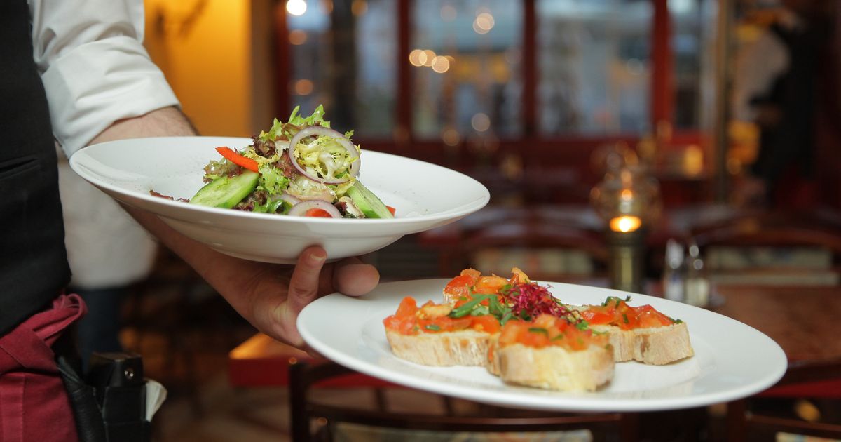 Chef plating a dish in a busy restaurant kitchen